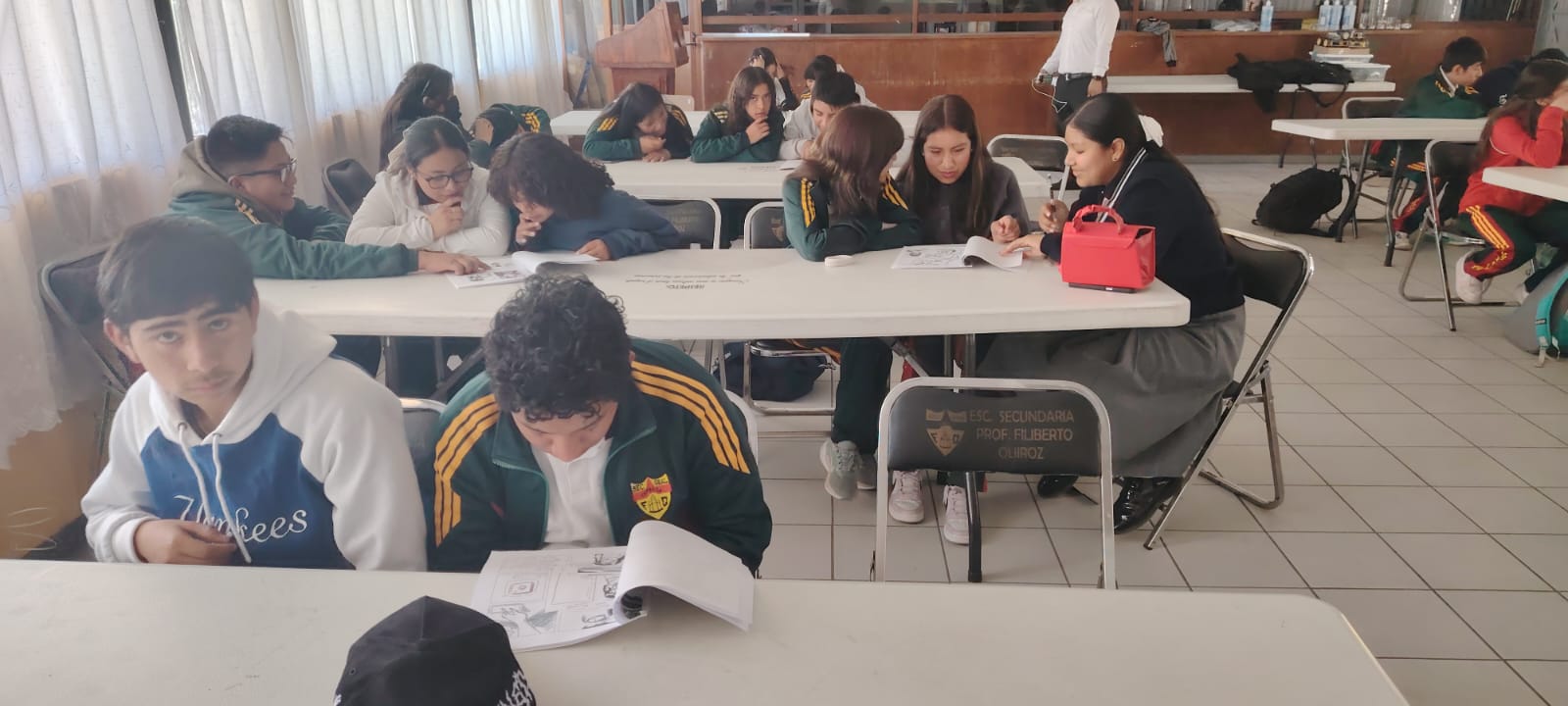 Alumnos de secundaria observando un experimento con asombro.